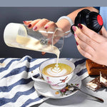 User pouring frothy milk with a semi-automatic frother into a decorative teacup for coffee art