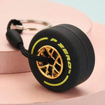 Luxury racing tire keychain featuring a detailed rubber tire design with gold accents
